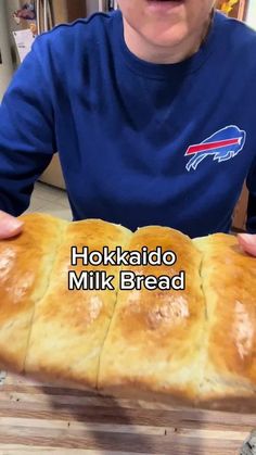 a person holding a loaf of bread with the words hokkadio milk bread on it