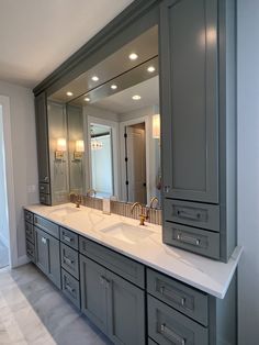 a large bathroom with double sinks and mirrors on the wall, along with two lights