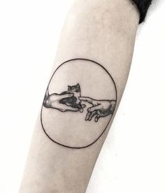 a tattoo on the arm of a woman with two hands touching each other in a circle