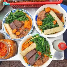 three plates filled with food on top of a table next to other dishes and utensils