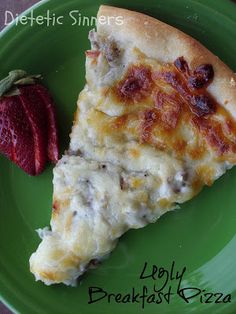 a slice of pizza on a green plate next to a strawberry