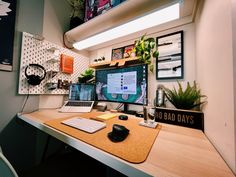 a desk with a computer monitor, keyboard and mouse on it in front of a window