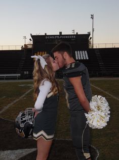 a man and woman kissing on the football field