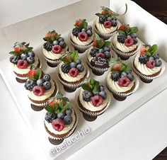 there are many cupcakes with berries on them