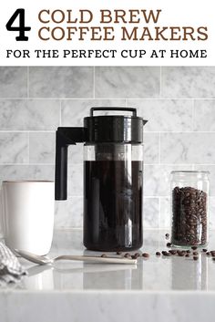 a coffee maker sitting on top of a kitchen counter next to a cup and spoon