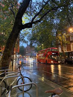 two bikes are parked on the side of the street in front of a red double decker bus