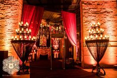 the entrance to an event with red curtains and chandeliers