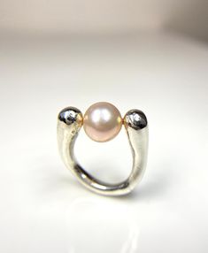 This is a one-of-a-kind spiral ring with a captivating design. Nestled at its center is a single pink Edison freshwater pearl, radiating an enchanting luster. The twisted band of the ring leads gracefully to two spherical ends, aligning seamlessly with the pearl, resulting in a mesmerizing composition.From every angle, this ring appears truly unusual and elegant! This is a Ready-to-Ship item! -Size US 7.25 width of band: about 3.5- 6.5mm -Pearl Information Pink Edison pearl  -Materials 925 silve Unique Polished Pearl Ring For Wedding, Unique Wedding Pearl Ring With Polished Finish, Edison Pearls, Spiral Ring, Twisted Band, South Sea Pearls, Tahitian Pearls, The Pearl, Tahiti