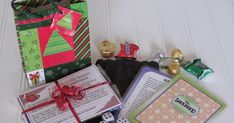 a pile of assorted candy and cards on top of a white table next to a bag