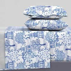 blue and white bedding with trees on them