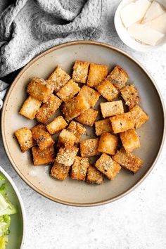 tofu cubes in a bowl with lettuce and sauce on the side