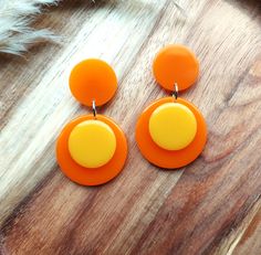 Add a touch of nostalgic charm to your look with these stunning 1960s style retro earrings which have been handmade in resin. They feature a vibrant colour block design in orange and yellow and their geometric shape adds a modern twist to their vintage-inspired appeal.  Perfect for any occasion, these earrings are sure to make a bold and stylish statement and they will make beautiful and unique gifts for lovers of mid century fashion. They measure 55mm x 30mm and they are finished with stainless Cheap Orange Retro Earrings, Geometric Jewellery, Mid Century Fashion, 1960s Style, Retro Earrings, Retro Earring, Yellow Colour, Statement Jewellery, Earring Posts