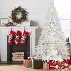 a white christmas tree with red and gold stockings