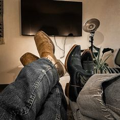 a person laying on the floor with their feet propped up in front of a flat screen tv