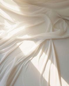 the white fabric is flowing in the wind on the bed sheet, with sunlight streaming through it