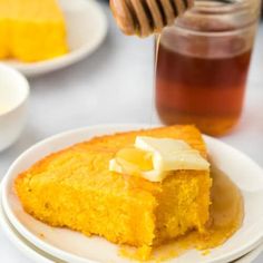 someone is drizzling honey onto a piece of cornbread on a plate