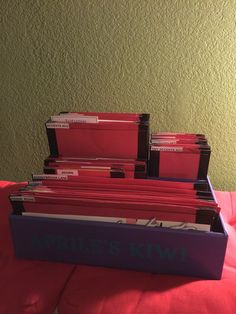 several folders stacked on top of each other in a blue and purple box with red labels