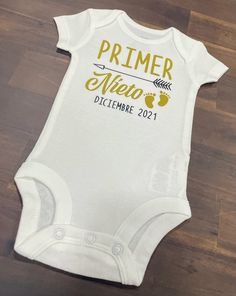 a white baby bodysuit with the words primer vien dicimbre 2012 printed on it