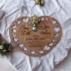 a heart shaped wooden plaque with flowers on it