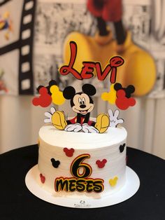 a white cake with mickey mouse on top and the word level 6 written in red