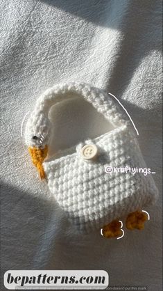 a crocheted white purse sitting on top of a bed