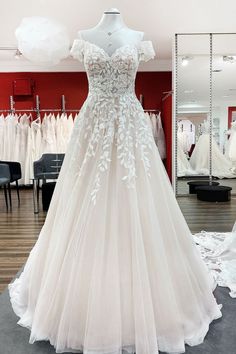 a white wedding dress on display in a store