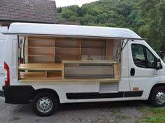 a white van parked in front of a house with open shelves on the back door