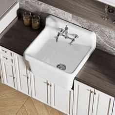 a white kitchen sink sitting on top of a counter next to a wooden countertop