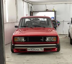 a red car is parked in a garage