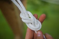 a person holding a white rope in their hand