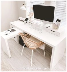 a white desk with a computer on it and a wicker chair next to it