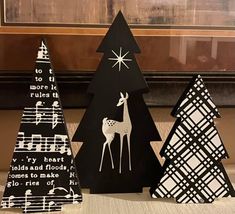 three black and white christmas trees with musical notes on them