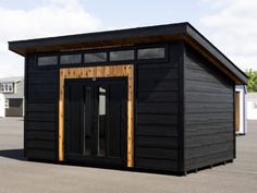 a small black building sitting on top of a parking lot