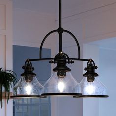 three lights hanging from a chandelier in a kitchen