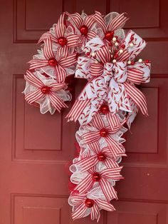 a red and white wreath hanging on the side of a door