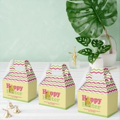 three small boxes with the words happy easter on them and a plant in the background