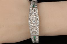 Stunning antique platinum bracelet with old european cut diamonds and emeralds. Item #B0024 Metal: Platinum Weight: 29.3 Grams Total Diamond Weight: Approximately 5.50 cts Diamond Color: H Diamond Clarity: VS2 - SI1 Measurements: 7 in x 5.5 mm Layaway: For your convenience, we will be happy to provide layaway payment options. Please contact us to work out a layaway plan which best suits your needs. All layaway purchases are final sale. All domestic and international shipments are shipped with Fe Formal Silver Diamond Bracelet With Emeralds, Fine Jewelry Emerald Diamond Bracelet For Wedding, Emerald Diamond Bracelet For Wedding, Wedding Emerald Diamond Bracelet, Elegant Emerald Diamond Bracelet For Wedding, Elegant White Gold Diamond Bracelet With Emerald, Elegant Green Engraved Bracelet, Elegant Green Engraved Bracelets, Platinum Bracelet