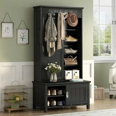 a black cabinet with shoes and hats on it next to a white couch in a living room