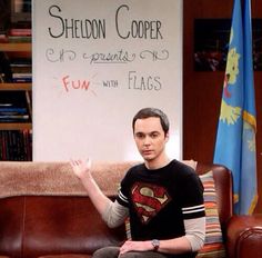 a man sitting on top of a brown couch in front of a white board with writing on it