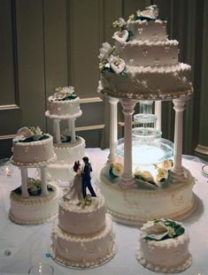 a table topped with three tiered cakes covered in frosting