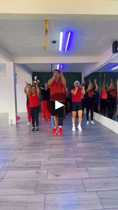 a group of people standing on top of a tiled floor next to each other in front of mirrors