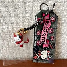 a hello kitty keychain with a hello kitty charm hanging from it's side