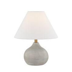 a table lamp with a white shade on the base and a light bulb in front of it