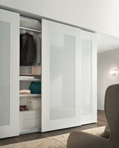 an open closet with white doors and drawers