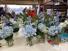 several vases filled with blue and white flowers