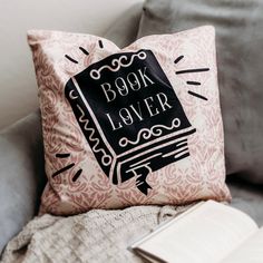 a pillow that says book lover on it next to a book and an open book