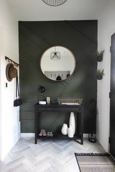 a black and white bathroom with a round mirror on the wall next to a sink