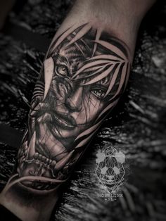 a man's arm with a black and white tattoo design on the left forearm