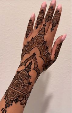 a woman's hand with henna tattoos on it