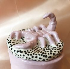 a cupcake with white frosting and black dots on it's top is shaped like a scorpion